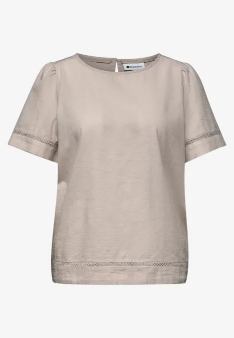 Beiges Damen-Oberteil mit kurzen Ärmeln und feinen Spitzenbordüren.