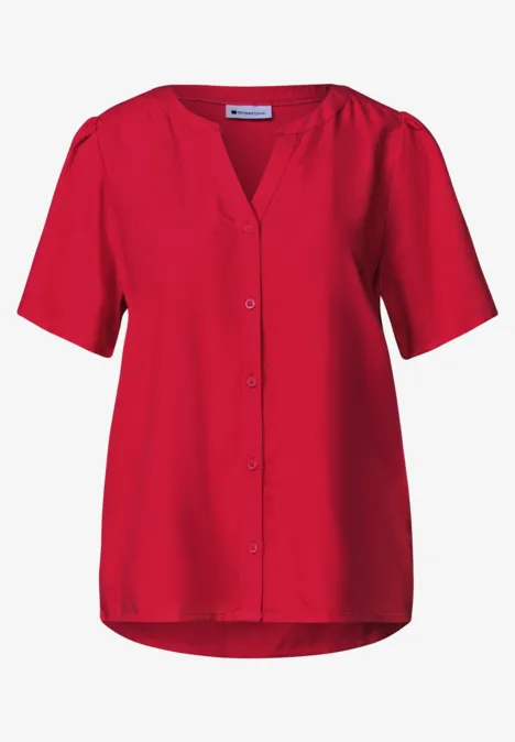 Chemisier rouge à manches courtes avec patte de boutonnage et encolure en V.