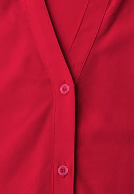 Cardigan rouge à col en V avec boutonnière en tissu doux.
