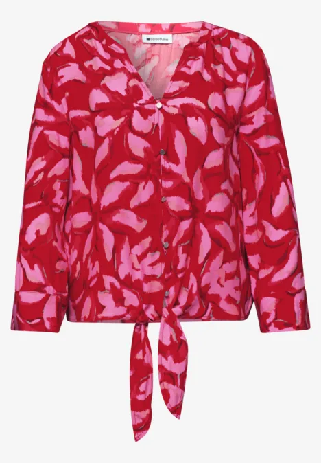 Rote Bluse mit pinkem Blattmuster, V-Ausschnitt, langen Ärmeln und Bindetail am Saum.