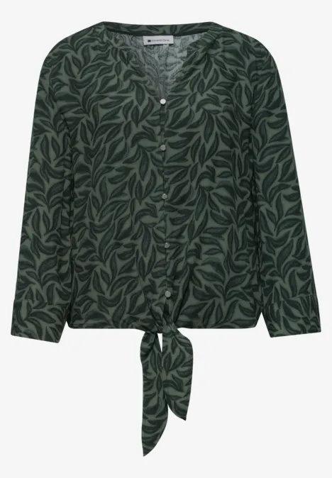 Dunkelgrüne Bluse mit Blattmuster, langen Ärmeln, Knopfleiste und vorne gebundener Schärpe.