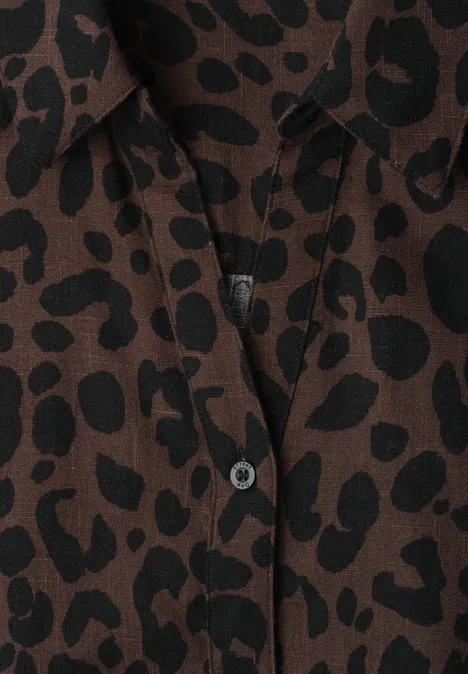 Gros plan d'une chemise brune à imprimé léopard noir avec bouton au col