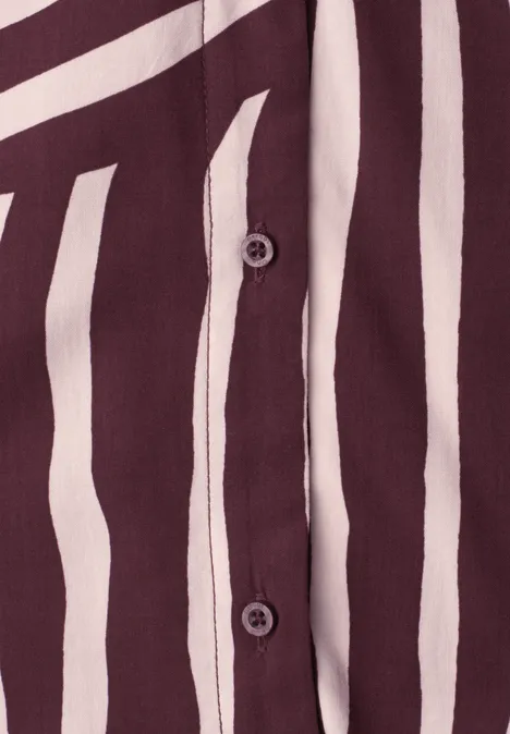 Close-up van een bordeaux gestreept overhemd met onregelmatige witte strepen en knoopsluiting.