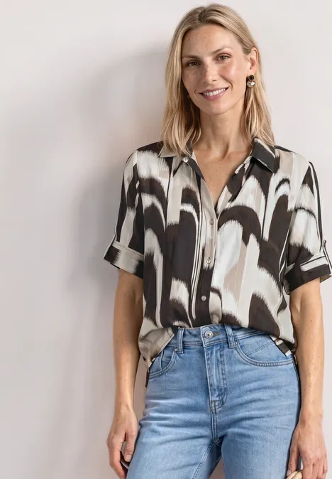 Kurzarm Hemdbluse mit Turn-Up-Details espresso brown Frau trägt schwarz-weiß gemustertes Kurzarmhemd in blaue Jeans gesteckt, stehend vor weißem Hintergrund.