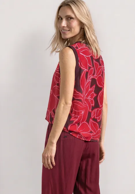Blusentop mit Rundhals und Tape-Detail salsa red Frau in rotem ärmellosem Top mit Blumenmuster und weinroter Hose vor hellem Hintergrund.