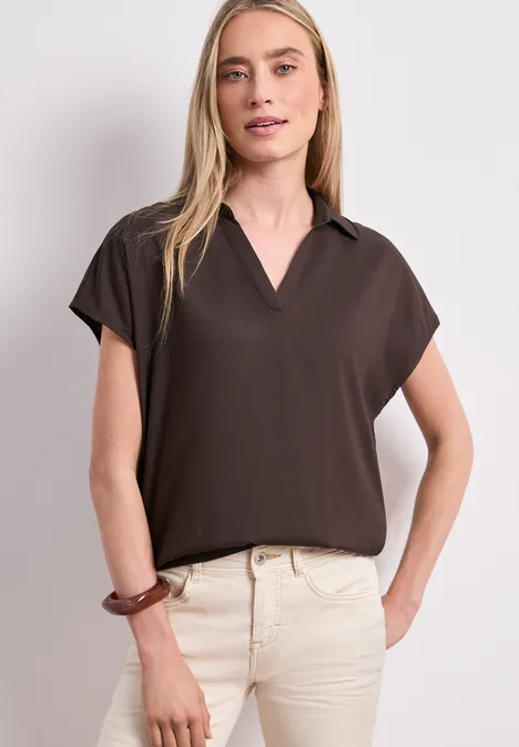 Chemisier à col chemise et ourlet élastiqué espresso brown Femme en chemise brune à manches courtes et pantalon beige, main sur la hanche.