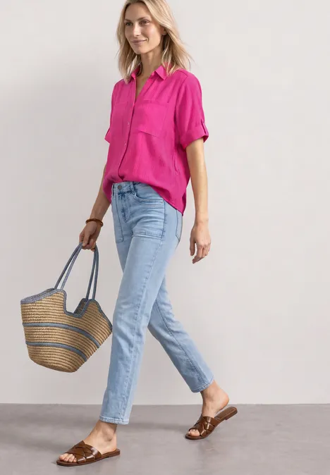 Chemisier à manches courtes à revers magenta dream Femme en chemise rose et jean clair tenant un panier en paille, sandales marron.