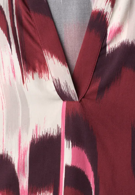 Blouse met V-hals en abstract penseelstreekpatroon in bordeaux, roze en grijs.