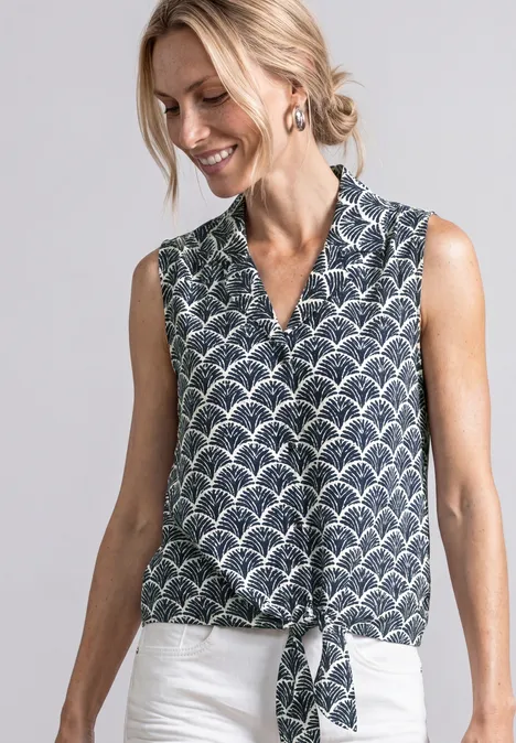 Top chemisier avec col bowling et nœuds shadowed navy Frau trägt ärmellose V-Ausschnitt-Bluse mit Schuppenmuster und Knoten vorne, kombiniert mit weißer Hose