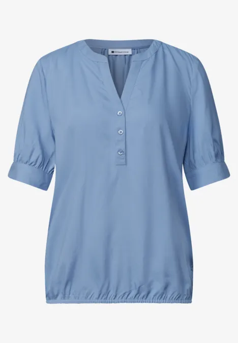 Blouse met korte mouwen, split in de hals en elastische zoom northern blue Lichtblauwe damesblouse met driekwart mouwen, knoopsluiting en elastische zoom.