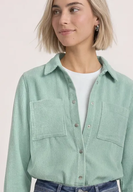 Corduroy overhemd met lange mouwen en knopen eucalyptus green Frau mit kurzem blonden Haar trägt hellgrünes Kordhemd über weißem T-Shirt.