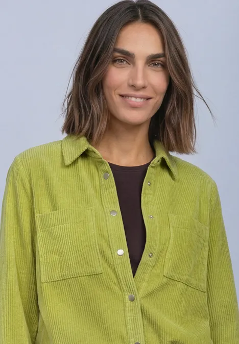 Corduroy overhemd met lange mouwen en knopen apple lime Frau mit schulterlangem braunen Haar trägt ein hellgrünes Cordhemd und lächelt in die Kamera.