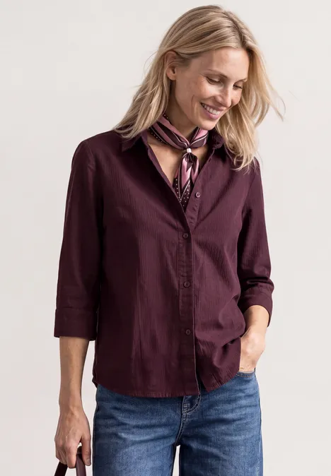 Overhemd met 3/4-mouwen en corduroy-mix rustic rouge Vrouw in bordeauxblouse, jeans en sjaal, glimlachend en neerwaarts kijkend
