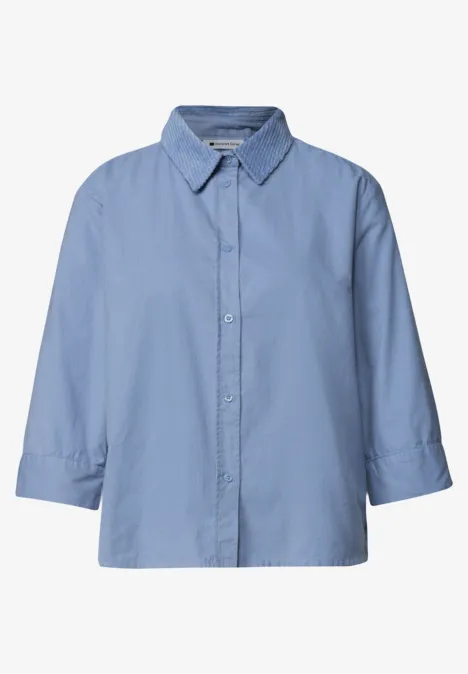 Lichtblauw damesblouse met 3/4-mouwen en knoopsluiting.