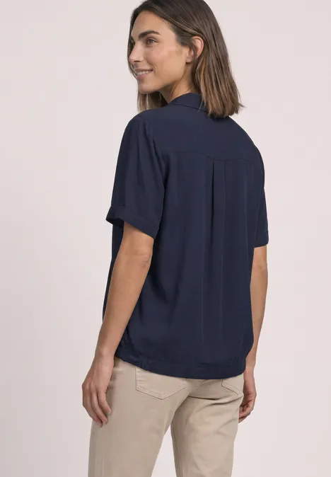 Overhemd met korte mouwen in effen kleur darkest blue Frau in dunkelblauer, kurzärmeliger Bluse und beiger Hose, seitlich stehend.