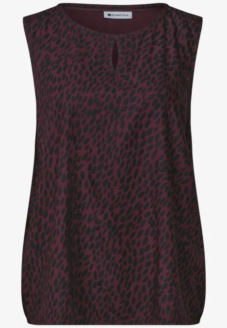 Damesmouwloze top in donkerrood met zwart luipaardprintmotief.
