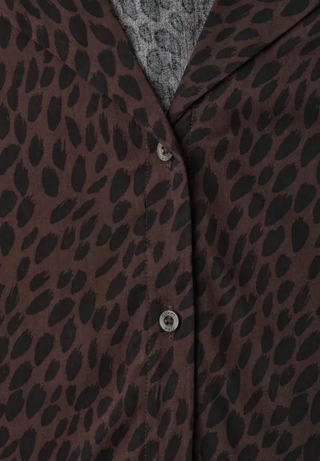 Braune Jacke mit schwarzem Blattmuster, zwei Knöpfe, grauer Pullover sichtbar