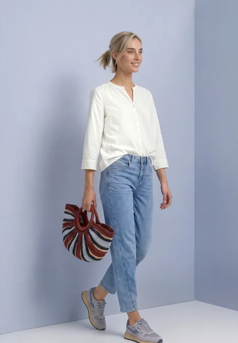 Blouse met 3/4-mouwen en split in de hals off white Junge Frau in weißer Bluse und Jeans posiert vor pastellfarbener Wand und hält eine bunte Tasche.