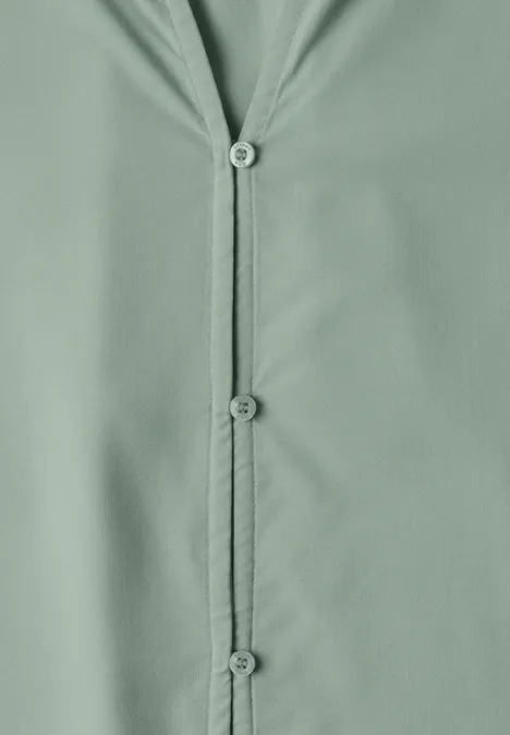 Blouse met 3/4-mouwen en split in de hals eucalyptus green Close-up van een lichtgroene knopenlijst op gladde stof.