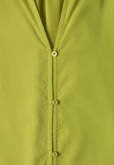 Blouse met 3/4-mouwen en split in de hals apple lime Close-up van een lichtgroen overhemd met zichtbare knopen en stiksels.