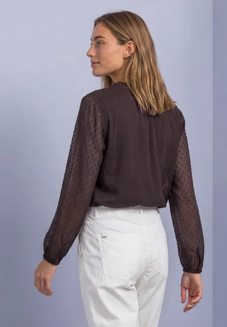 Chiffonblouse met split in de hals en bandjes ruby vine Vrouw in zijaanzicht met een bruin blouse en een witte broek voor een neutrale achtergrond.