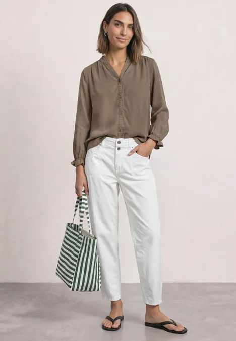 Blouse met 3/4-mouwen, split in de hals en ruches saddle brown Frau in legerer taupe Bluse, weißen High-Waist-Hosen und schwarzen Sandalen trägt grün-weiß gestreifte Tasche.