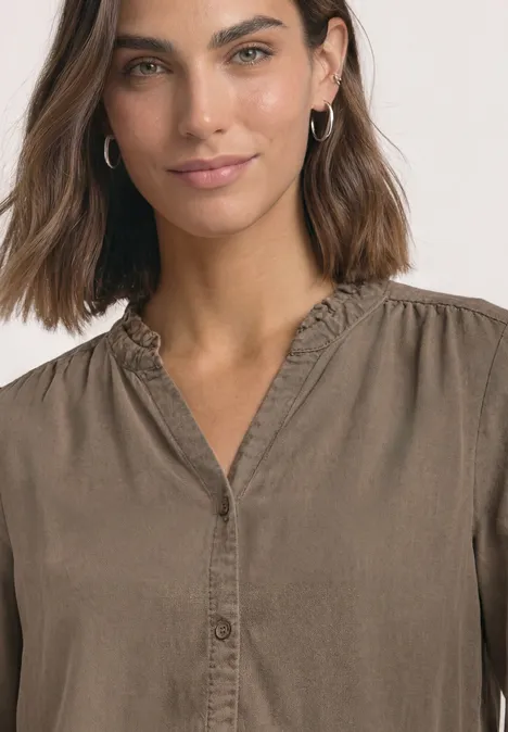 Blouse met 3/4-mouwen, split in de hals en ruches saddle brown Porträt einer Frau mit schulterlangen braunen Haaren, brauner Bluse und Creolen, leicht lächelnd
