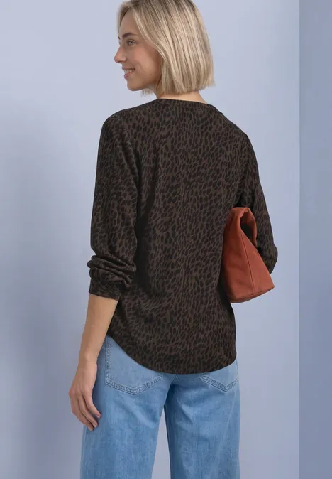 Langarm Bluse mit Split Neck und Print molten earth Frau von hinten, schwarzes Shirt mit braunem Leomuster, blaue Jeans, hält cognacfarbene Tasche.