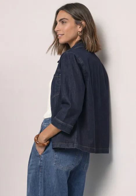 Denim overhemd in rinsed-look Rinse Soft Washed Junge Frau in Denim-Jacke und Jeans, seitlich stehend und lächelnd, vor neutralem Hintergrund.