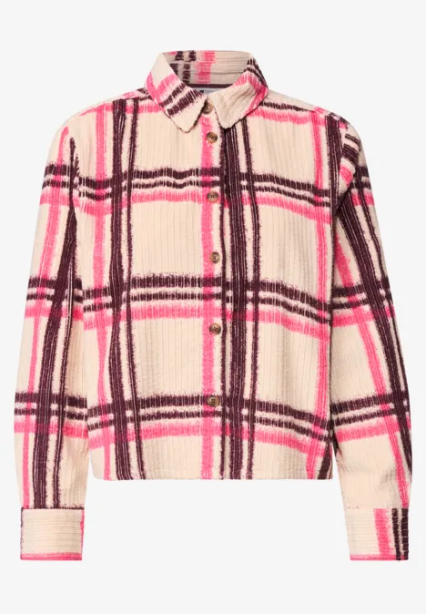 Veste-chemise duveteuse beige à carreaux rose et marron, avec col, poche poitrine et fermeture à boutons.