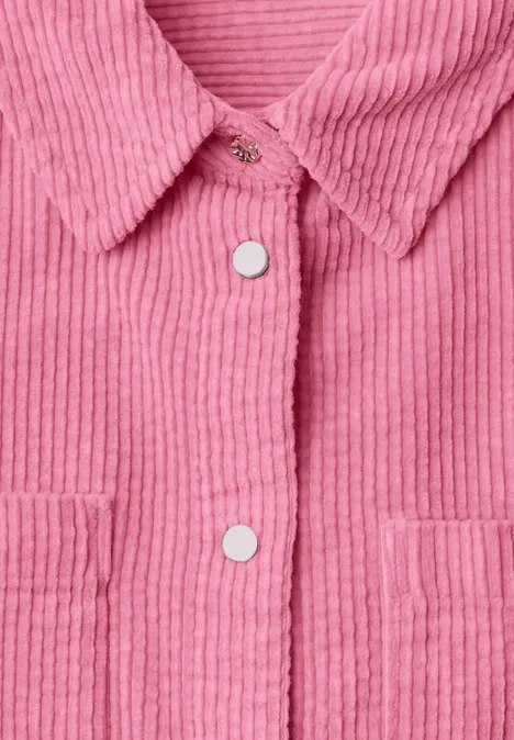 Roze corduroy jasje met overhemdkraag, witte drukknopen en opgestikte zakken.