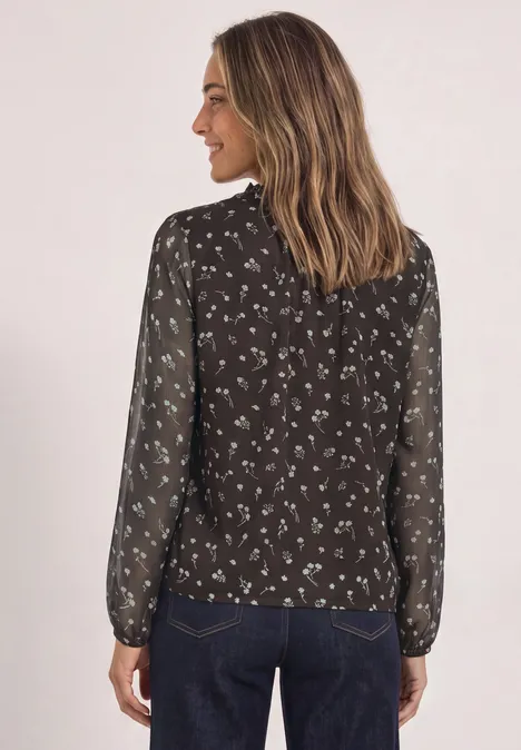 Langarm Chiffon-Bluse mit Split Neck black coffee Frau von hinten in schwarzer, transparenter Bluse mit weißem Blumenmuster und blauer Jeans.