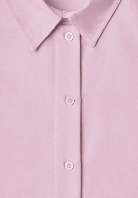 Close-up van een roze overhemdkraag met drie knopen centraal op de voorkant.