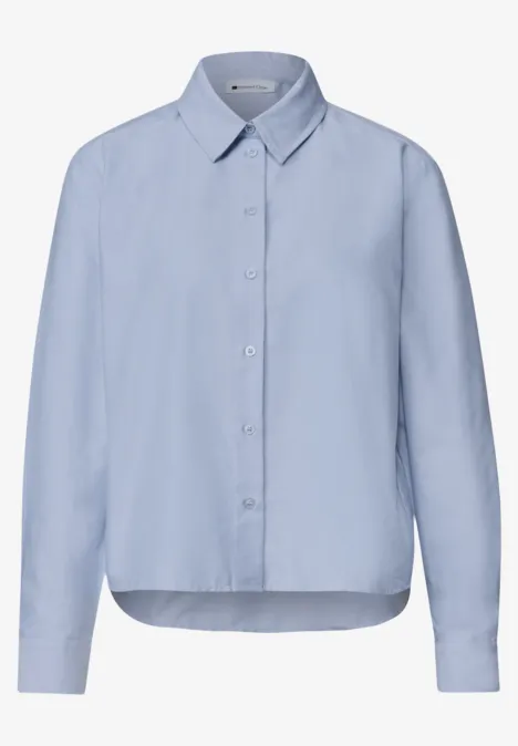 Chemise bleu clair à manches longues avec col et patte de boutonnage.
