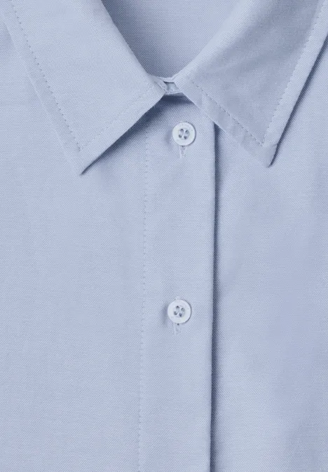 Chemise bleu clair avec col pointu et deux boutons apparents.