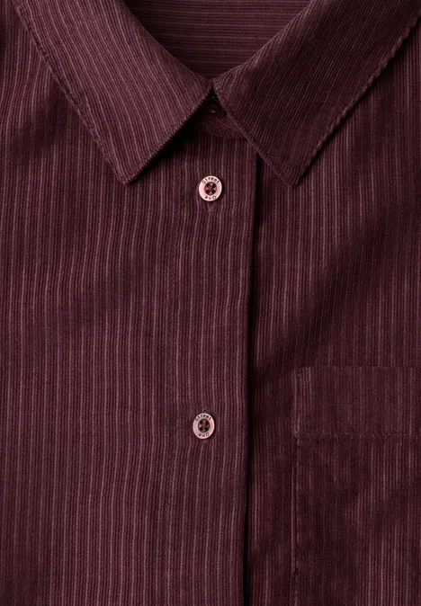 Une chemise bordeaux à fines rayures, col et boutons apparents.