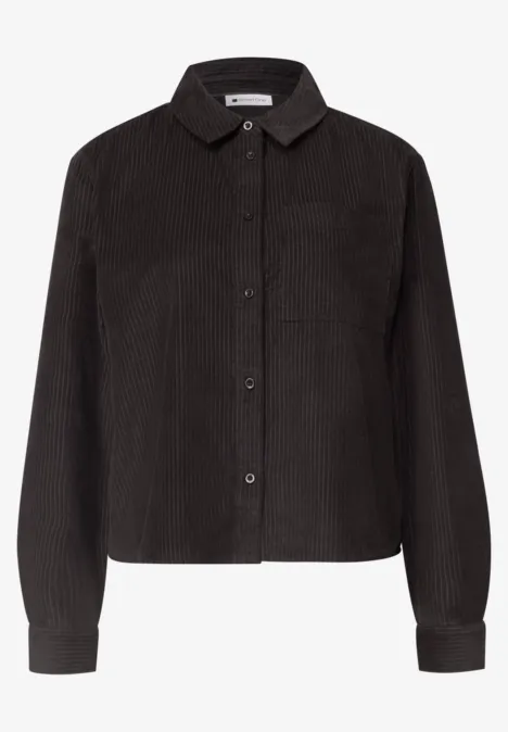 Chemise noire en velours côtelé avec col, boutons et manches longues.
