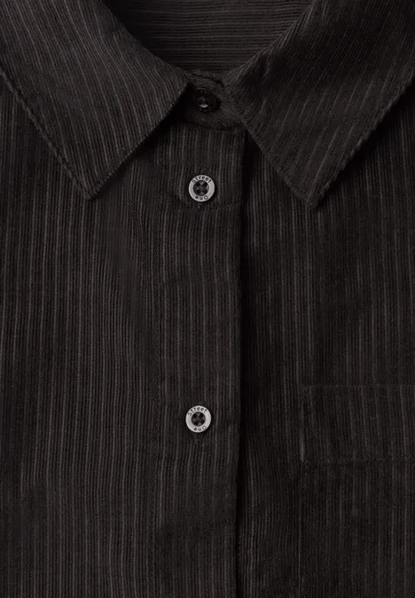 Gros plan sur une chemise sombre à fines rayures verticales, col et patte de boutonnage visibles.
