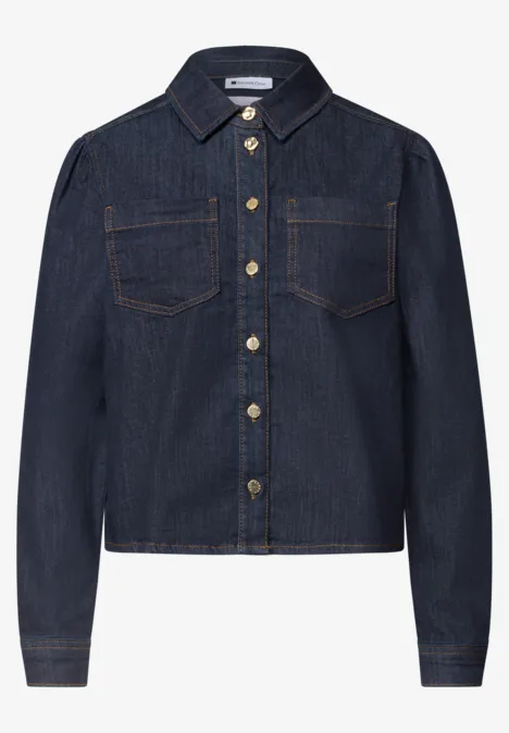 Veste en jean bleu foncé avec col chemise, poches poitrine et boutons dorés.