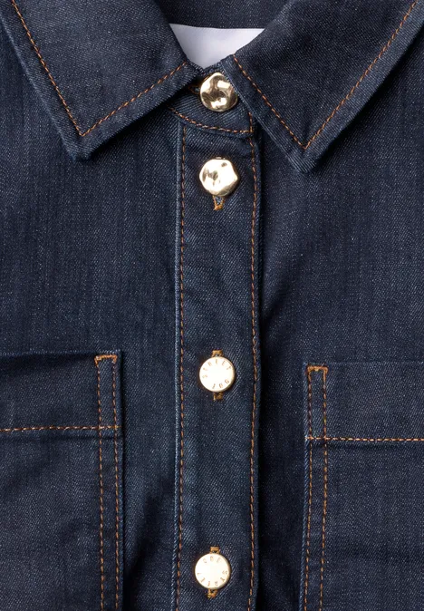 Veste en jean foncée avec boutons dorés, deux poches poitrine et surpiqûres orange contrastantes.