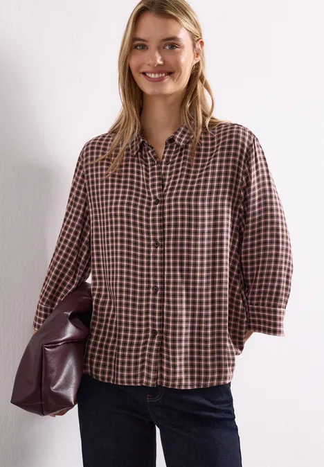 3/4-Arm Hemdbluse mit Karomuster warm blush Eine lächelnde Frau trägt eine karierte Bluse, Jeans und hält eine große Handtasche aus Leder.