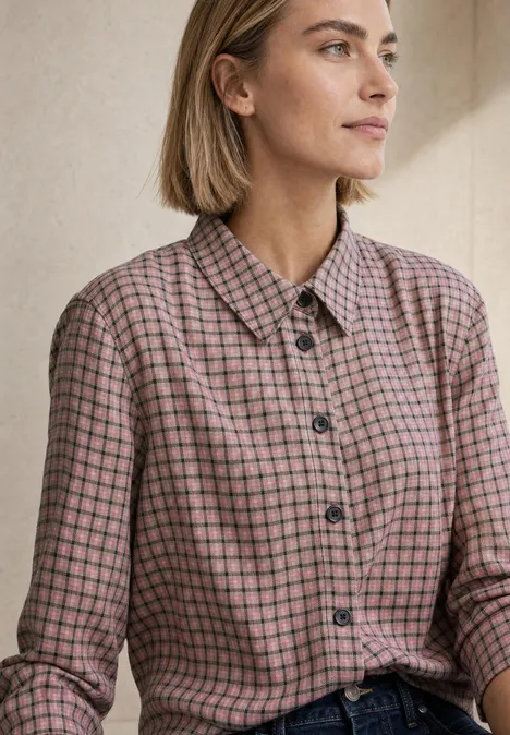 Langarm Hemdbluse mit Karomuster warm blush Eine junge Frau mit schulterlangem Haar trägt eine karierte Bluse und blickt nach rechts.