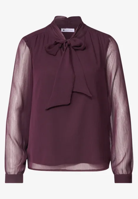 Blouse en chiffon violet foncé avec col noué et manches longues transparentes.