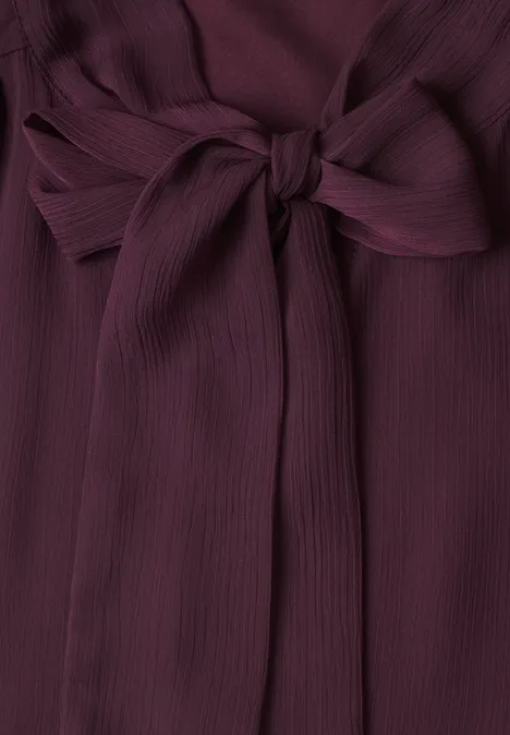 Tissu côtelé bordeaux orné d’un nœud décoratif
