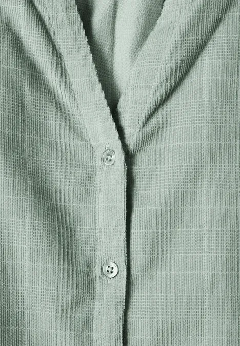Chemise verte texturée à motif carreaux subtils, vue rapprochée sur la patte de boutonnage et le col.