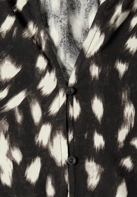 Schwarz-weißer Cardigan mit unregelmäßigen Tupfen im Animal-Muster.