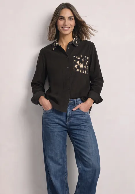 Chemisier à manches longues avec des détails imprimés représentant des chevreuils black coffee Femme souriante en chemise noire à col et poche imprimés, portant un jean bleu