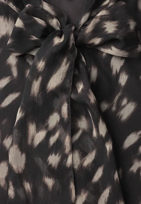 Top noir à motifs de taches claires irrégulières avec nœud à l'encolure