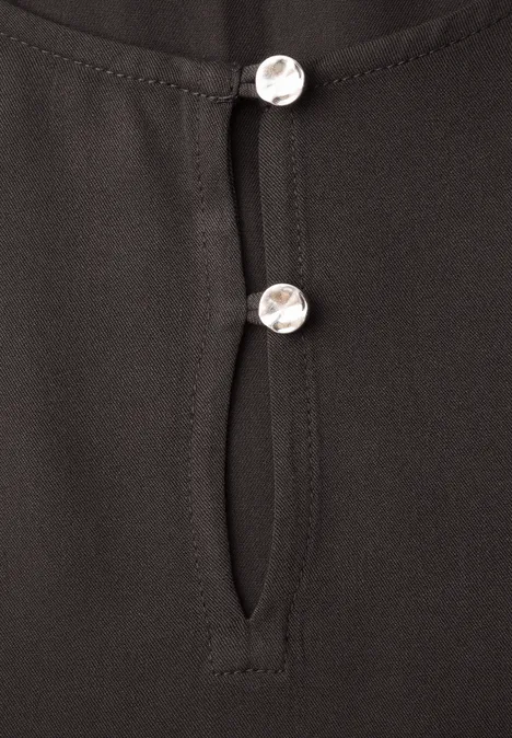 Chemisier à manches longues et à basque black coffee Haut noir avec patte de boutonnage et deux boutons argentés.