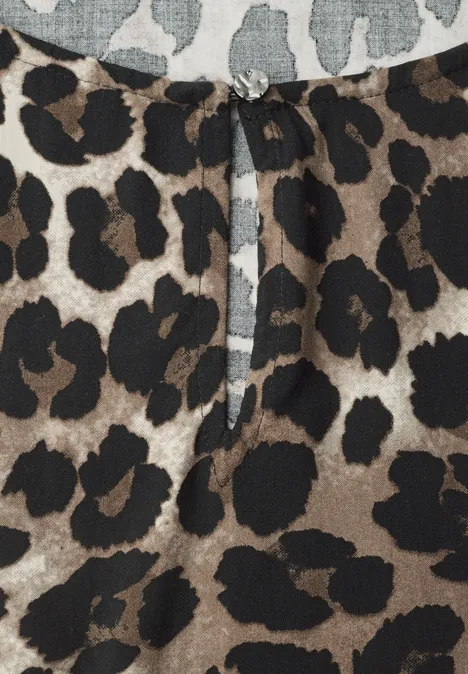 Damenbluse mit braun-schwarzem Leopardenmuster und kleinem Keyhole-Ausschnitt mit funkelndem Zierknopf.